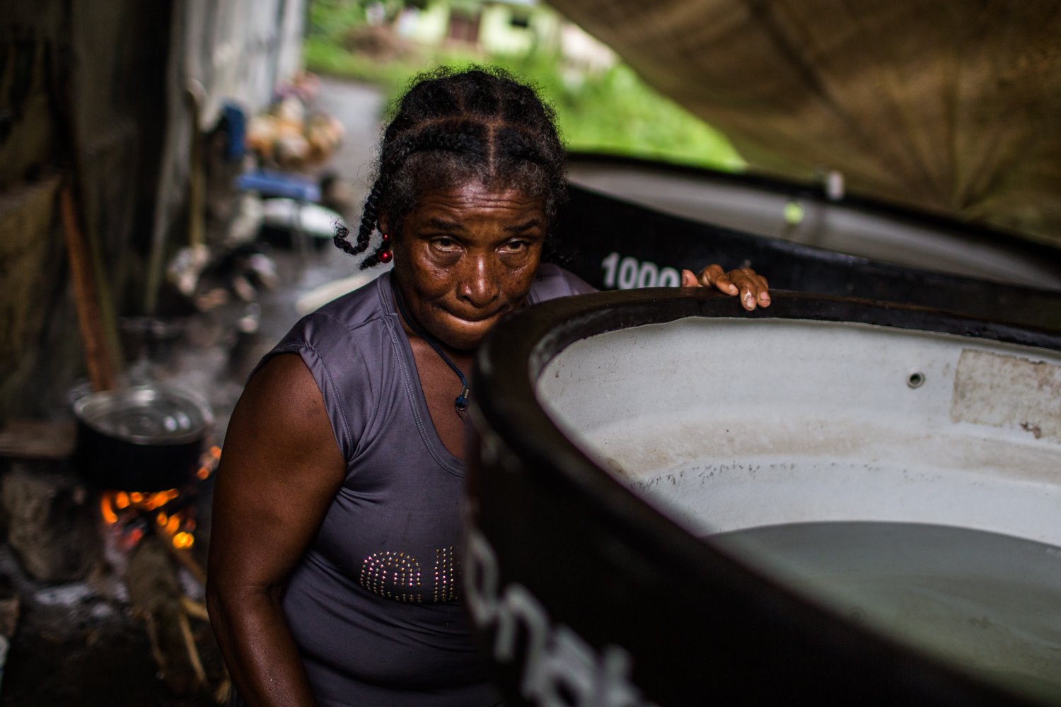 Una mujer desplazada busca agua en tanques ubicados a las afueras del polideportivo donde se alojan docenas de víctimas. | Foto: Mauricio Morales/¡Pacifista!