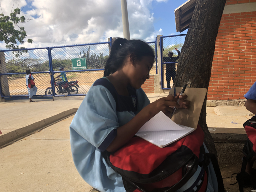 Estudiante indígena wayúu, aprovecha la hora del recreo para ponerse al día con las tareas. Crédito: Betty Martínez.
