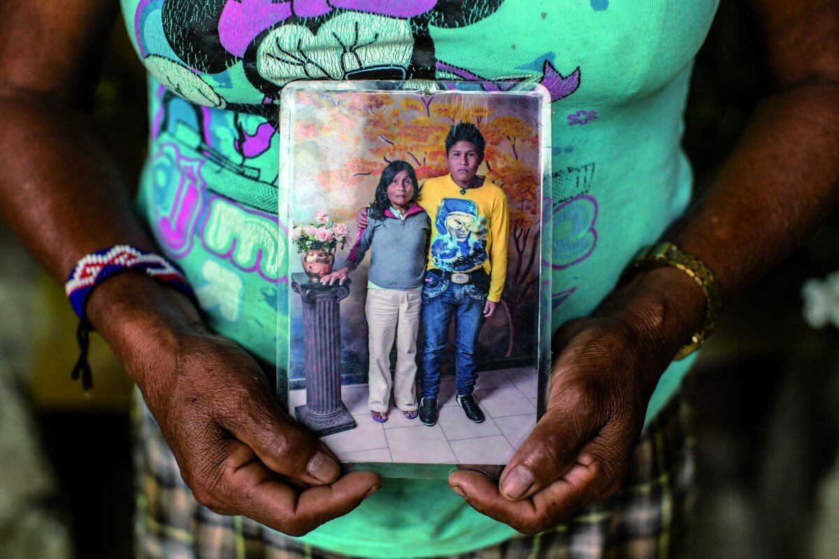 2014, Colombia. Elsa, una mujer indígena del Chocó, pasó una década sin saber de su hijo, quien ingresó a un grupo armado a los 8 años. Elsa muestra el retrato que se tomaron durante el reencuentro gracias al CICR. Juan Arredondo/CICR